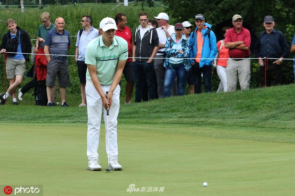 马修·菲茨帕特里克凝神注视果岭,眼神锐利如鹰,手握推杆准备关键时刻的一击