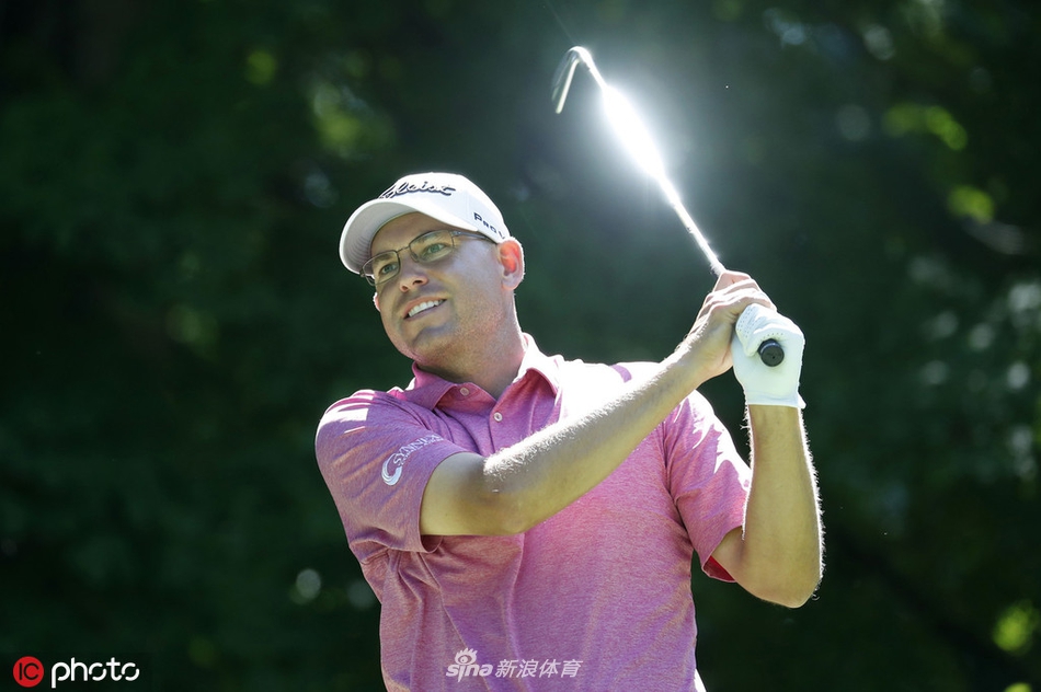 TPC鹿场绿树成荫的球道全景，球员在宽阔的球道上准备击球，展现了赛事举办地的优美环境。