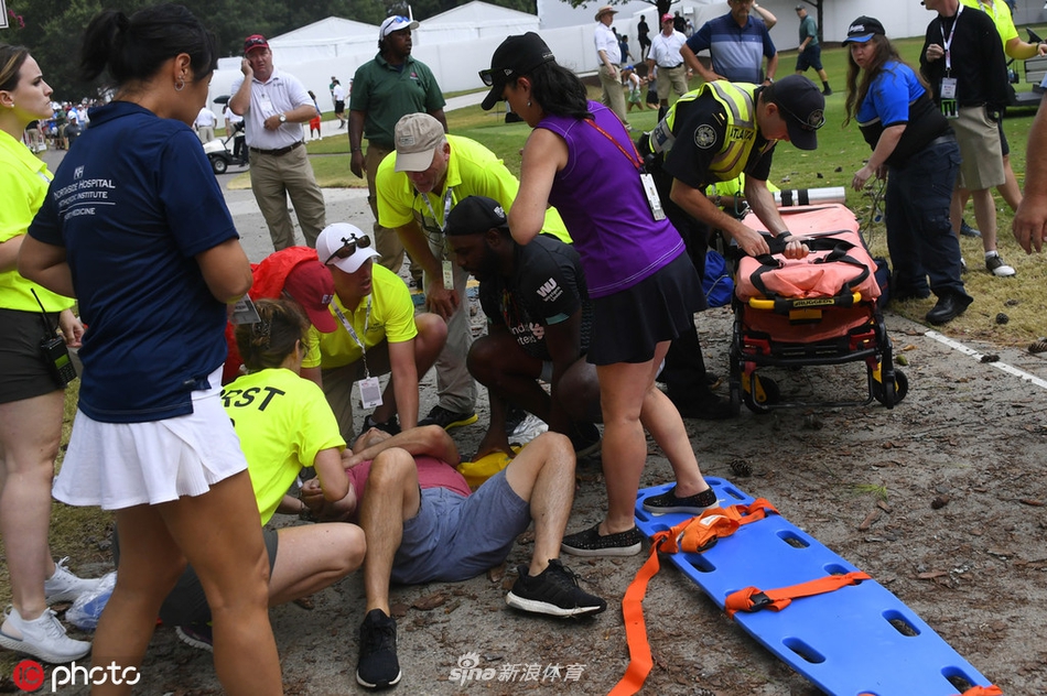 赛事记分牌上显示着天气延迟的公告,观众在远处驻足观望
