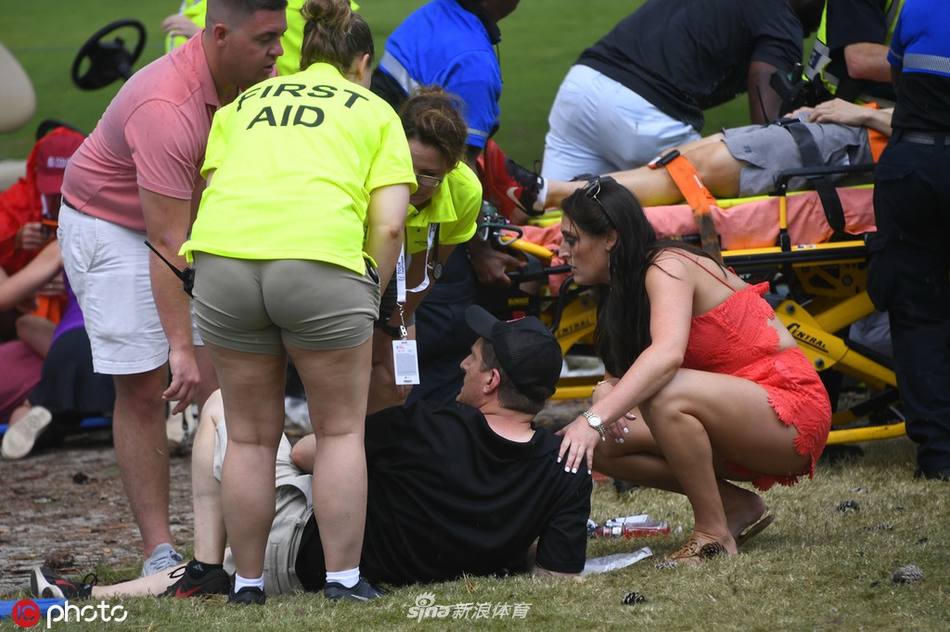 医疗团队在球场边围成一圈,对一名坐着的伤者进行初步检查和包扎