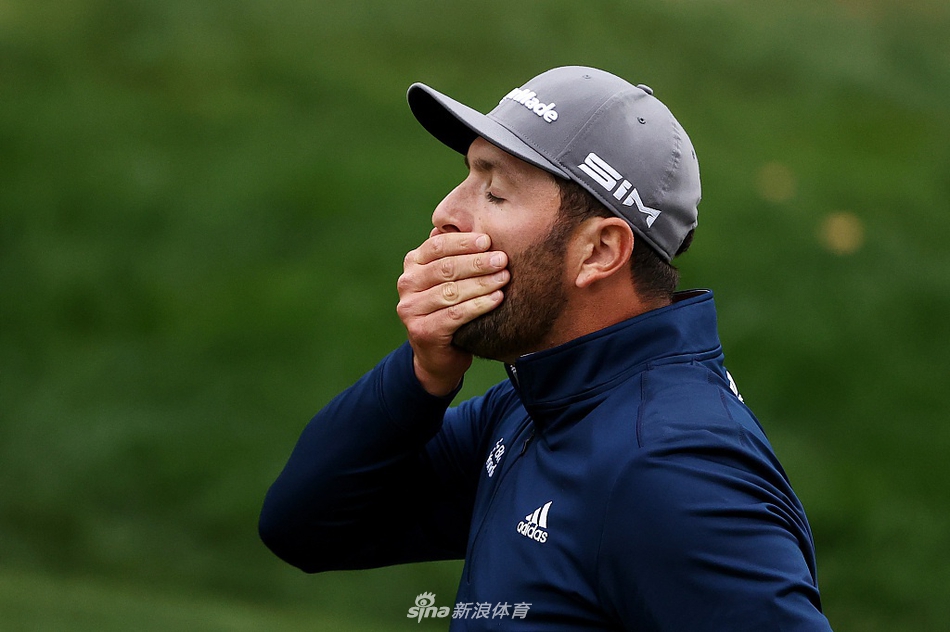 贾斯汀·托马斯在果岭边细致观察线位，思索切杆策略