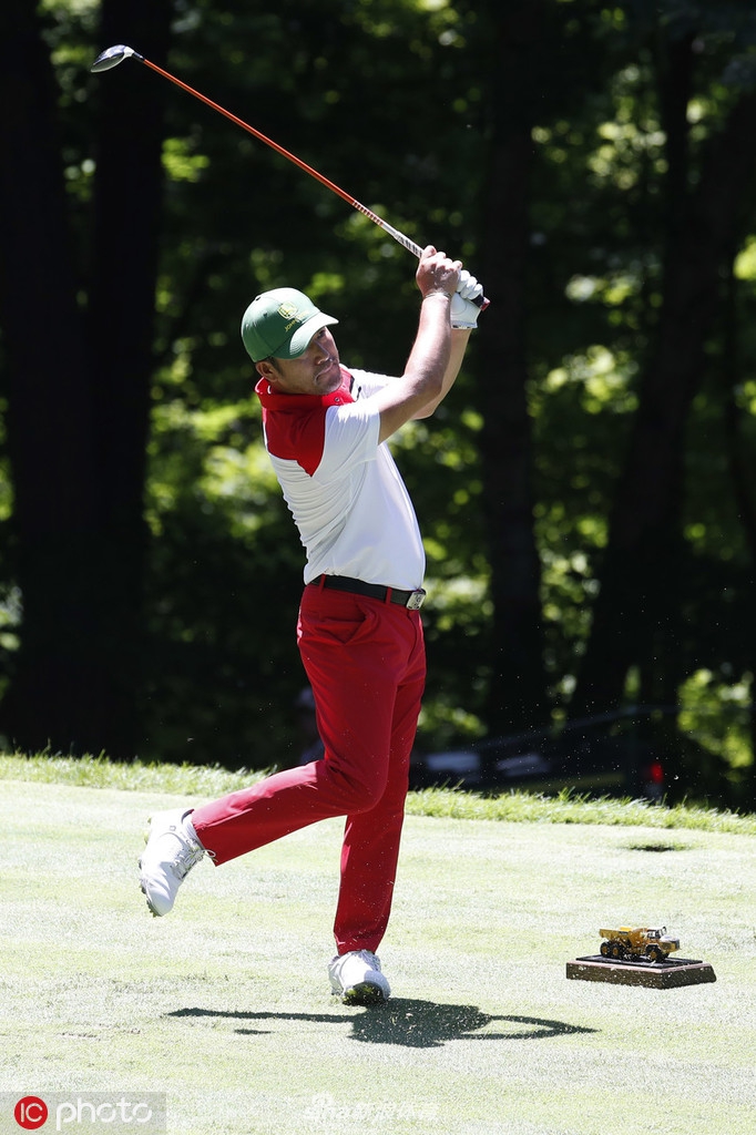 球员在沙坑中成功救球后露出笑容，沙粒飞溅的瞬间捕捉了高尔夫技巧与临场应变的能力。