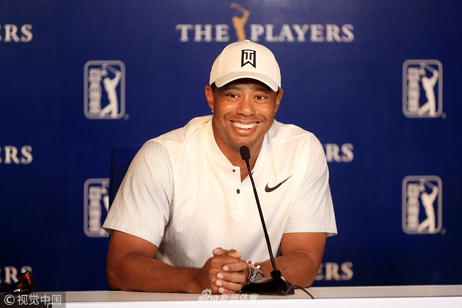 备战间隙老虎伍兹展露轻松笑容，与团队成员亲切交谈