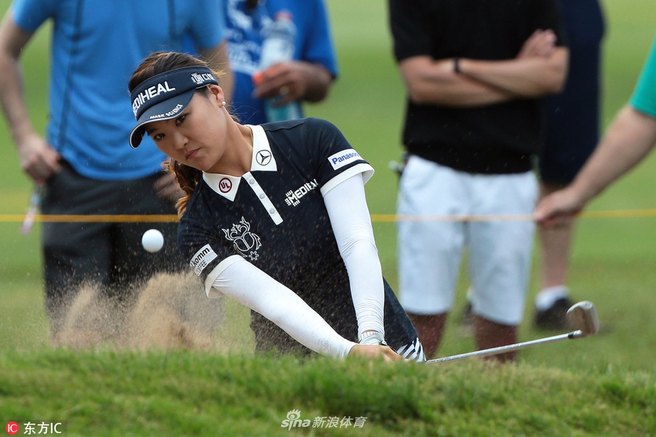 刘钰在果岭上仔细研判推杆线路，表情专注，准备击出关键一推