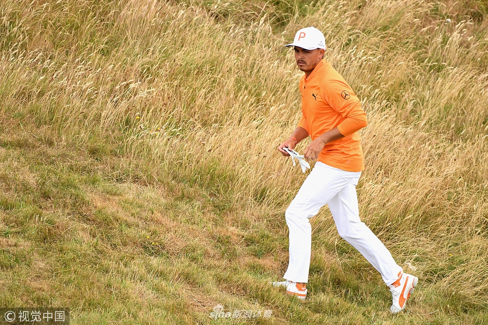 里奇·福勒提着球包步入古兰球场极具挑战性的长草区，评估球位。