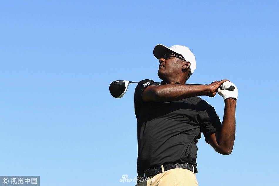 厄尼·埃尔斯在练习果岭边专注切杆，表情平静，背景是球场辽阔的远景