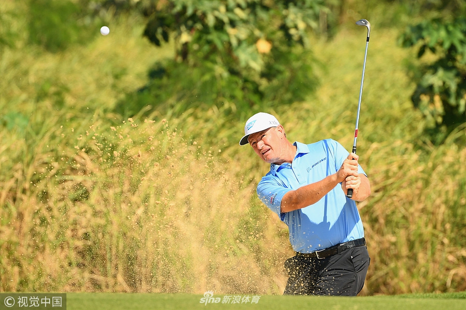 厄尼·埃尔斯在沙坑中练习救球，身体舒展，沙粒飞扬，展现经典技巧