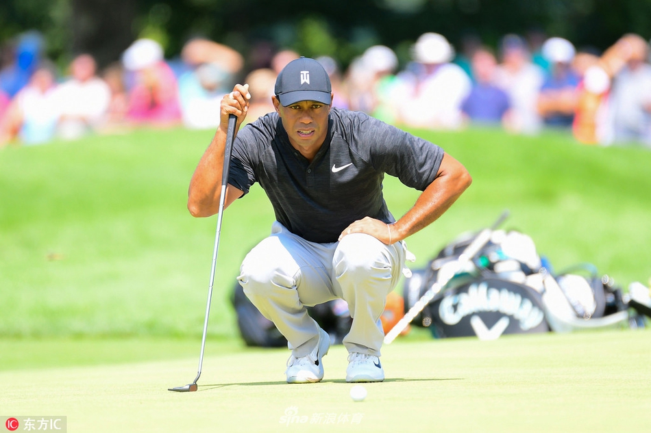 伍兹在沙坑中救球,沙砾飞扬,展现了他处理困难球位时精湛的技术与专注力。