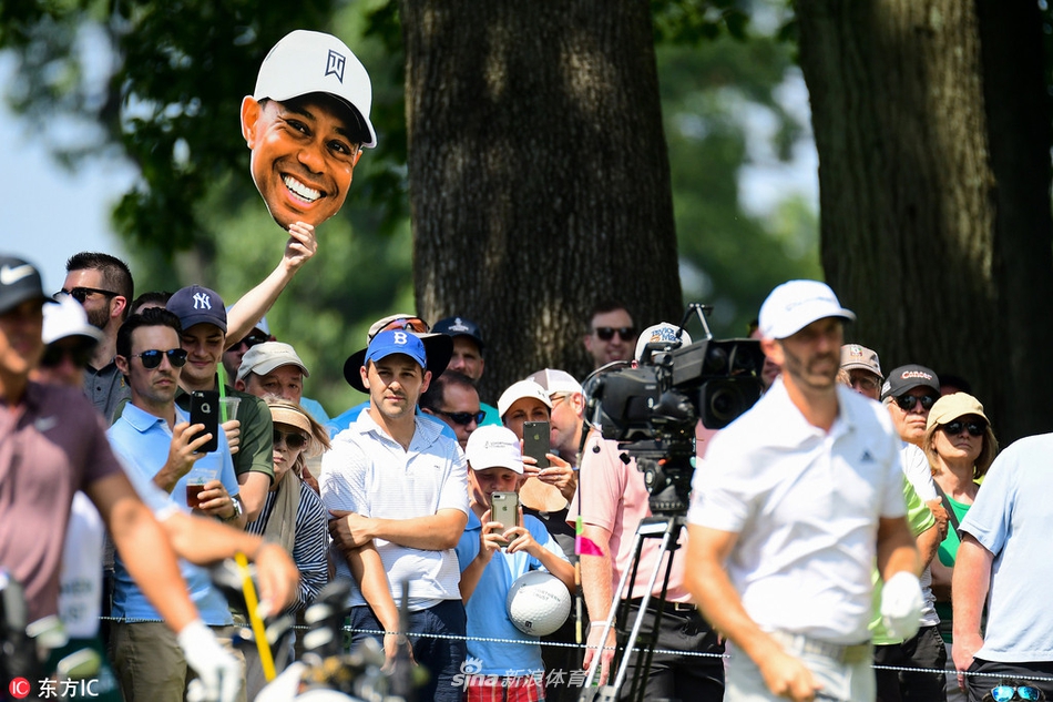 夕阳余晖下,伍兹独自走在赛场边缘,长长的身影映在草地上,画面宁静而充满故事感。