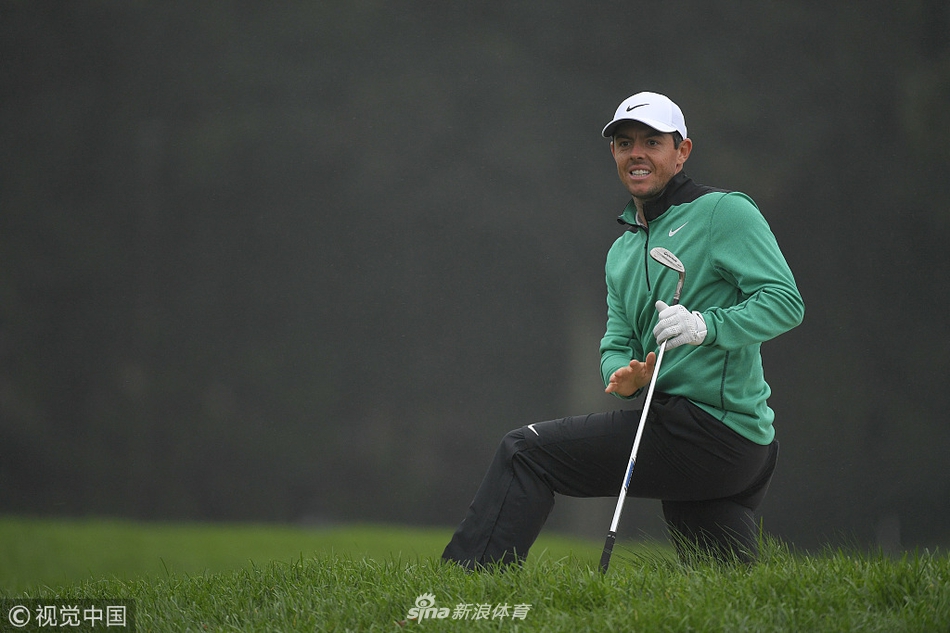 比利·霍雪尔在果岭上凝视着刚刚错失关键推杆的球洞，表情凝重，身体姿态流露出深深的惋惜与不甘。