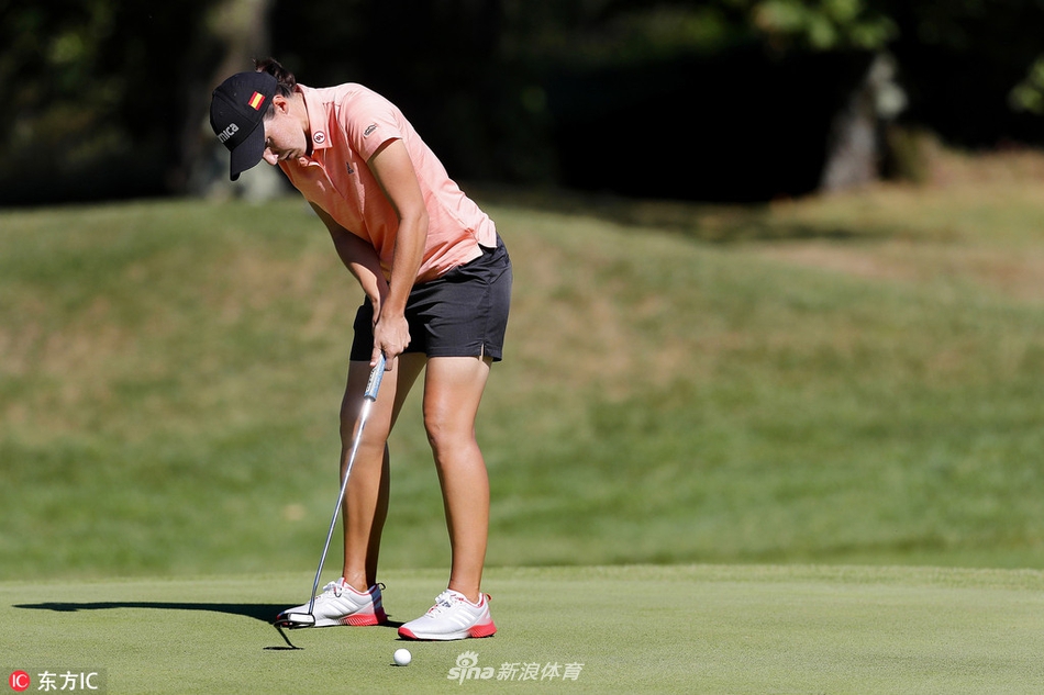 夕阳下的依云球场全景，球道如绿丝带蜿蜒在群山之间