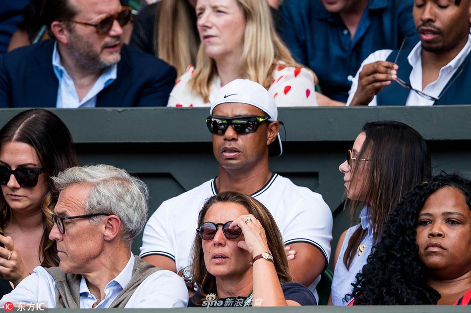 伍兹在巡回锦标赛决赛轮中专注推杆,巨大的观众人群聚集在果岭周围,屏息凝神。