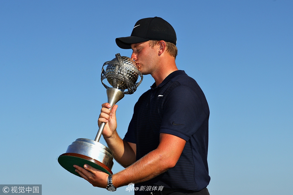 冠军汤姆-路易斯在果岭上优雅挥杆开球,动作标准而充满力量,目光专注地望向前方。