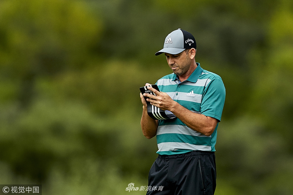 李·维斯特伍德与年幼的儿子并肩走在球道上，父子二人步伐一致，分享着高尔夫球场上的亲密时光。