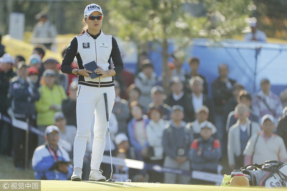 李旻智在果岭边凝神观察推杆线路，眼神专注，展现了顶尖球手决胜时刻的沉着与自信。