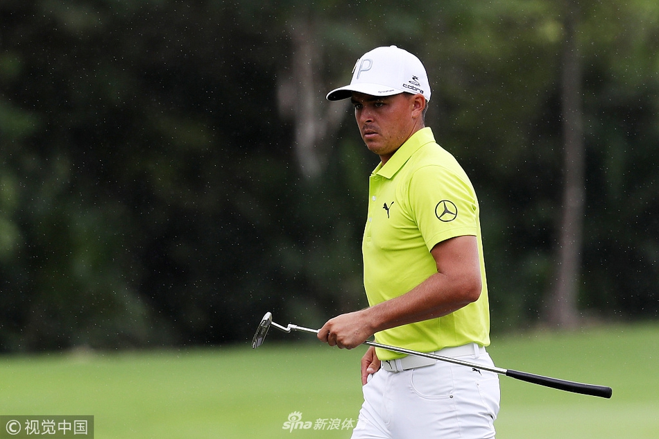 里奇·福勒深陷果岭边沙坑，他正全神贯注地准备击球，沙坑杆划出一道弧线，激起一片白色的沙浪。