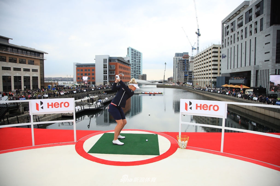 汤米·弗利特伍德与查莉·赫尔在果岭旁轻松交流，赫尔面带微笑，气氛愉快。