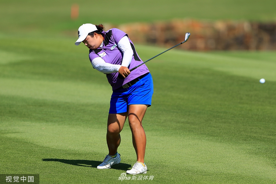 韩国选手金孝周在长草中沉着处理困难球位，她全神贯注准备击球，展现了应对挑战的专业能力。