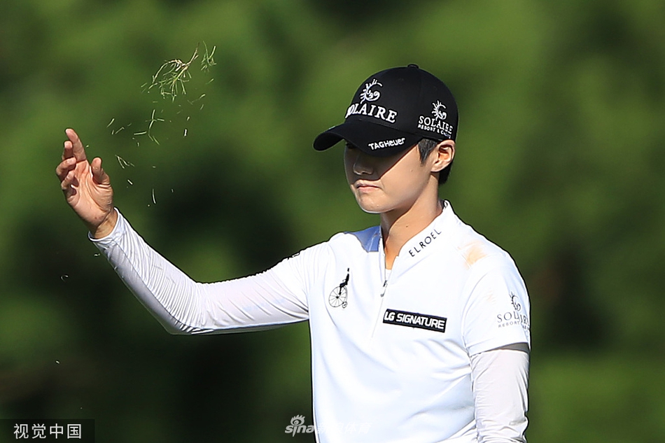 朴城炫在山顶乡村俱乐部果岭边凝神观察推杆线路，阳光洒在草地上，她沉稳的姿态彰显冠军的专注与决心。