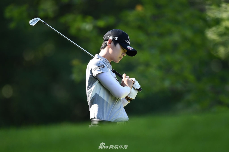 刘钰在果岭边细致观察推杆线路，微风拂过她的帽檐，神情中透露出超越年龄的沉着与专注。