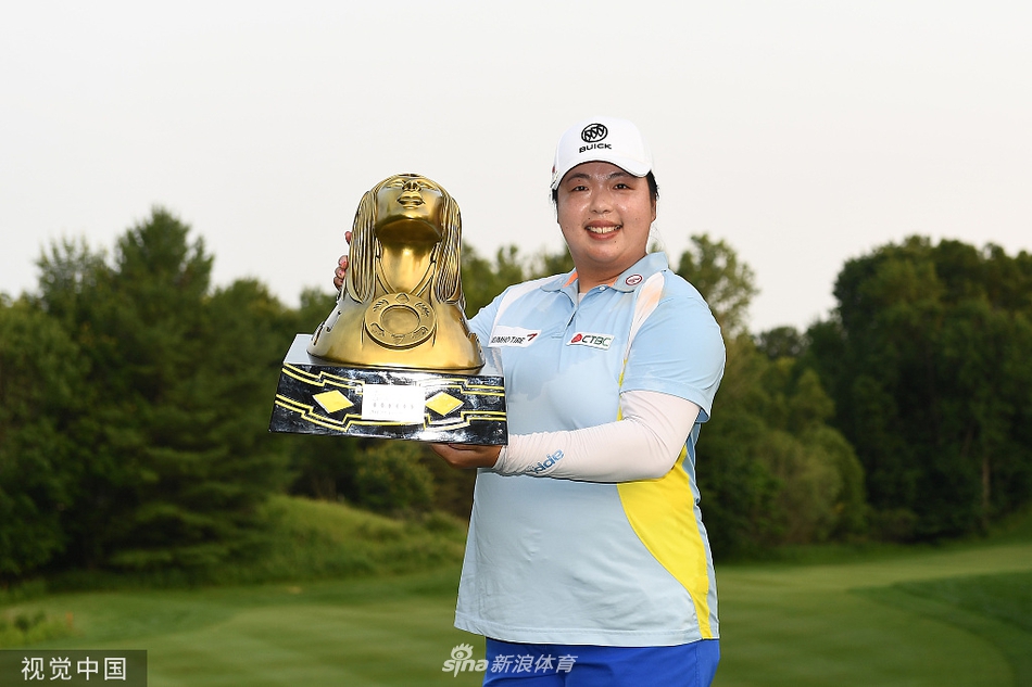 冯珊珊高高举起刺莓溪精英赛冠军奖杯，身披荣光，向观众席展示这来之不易的胜利果实