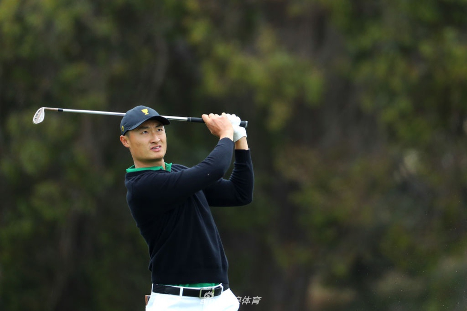 老虎伍兹在皇家墨尔本第四洞果岭边凝神观察,阳光洒在他专注的脸庞上,大战前的宁静蕴含着无尽力量。