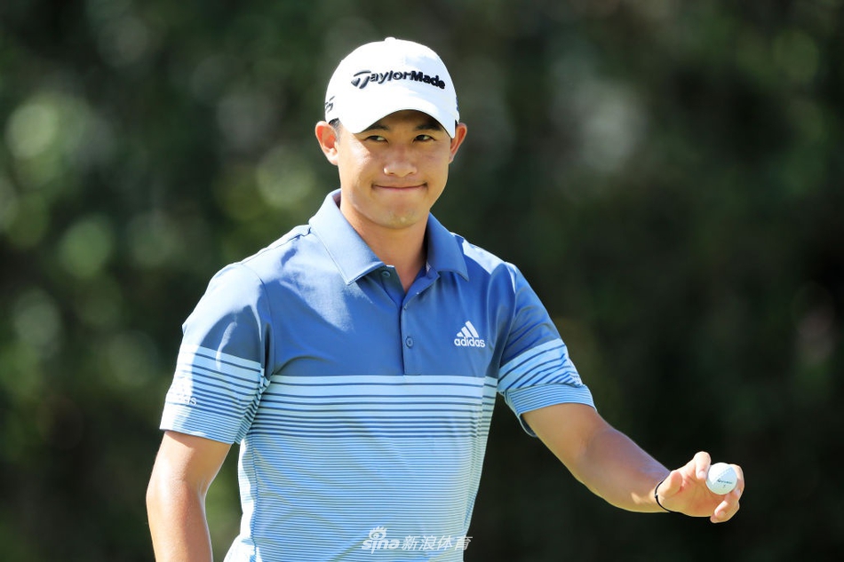 科林-森川在瓦伊莱乡村俱乐部第九洞果岭边凝神观察线路,身后是摇曳的棕榈树与起伏的果岭,夏威夷的强风让这场较量充满挑战。