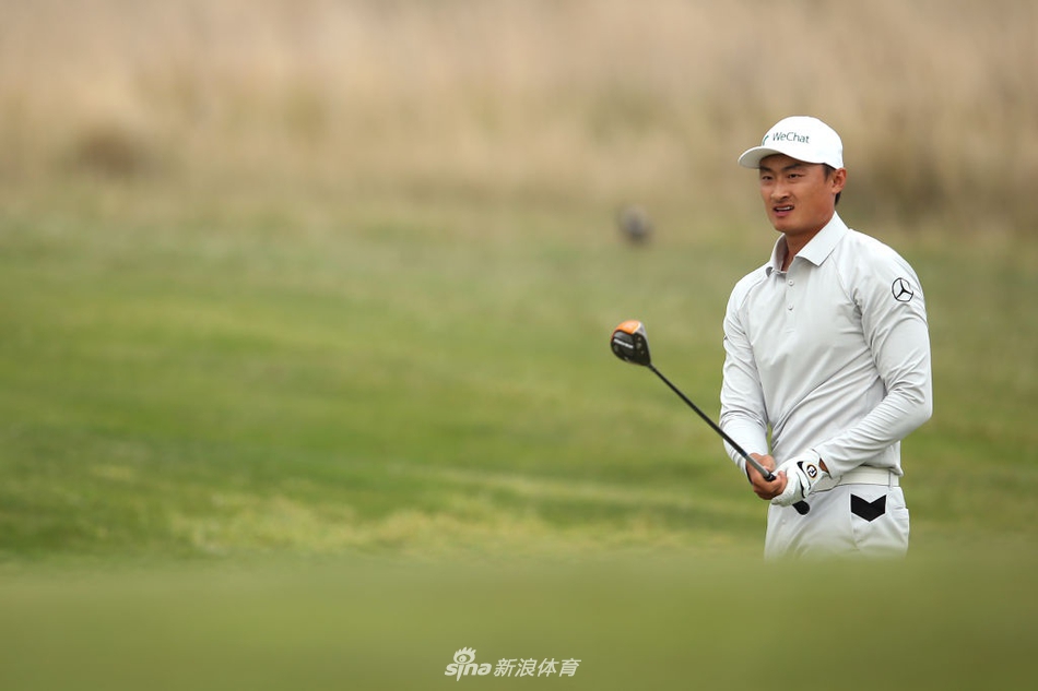 夕阳下，李昊桐与球童在球道上并肩行走，共同分析下一杆的策略，身影拉得很长