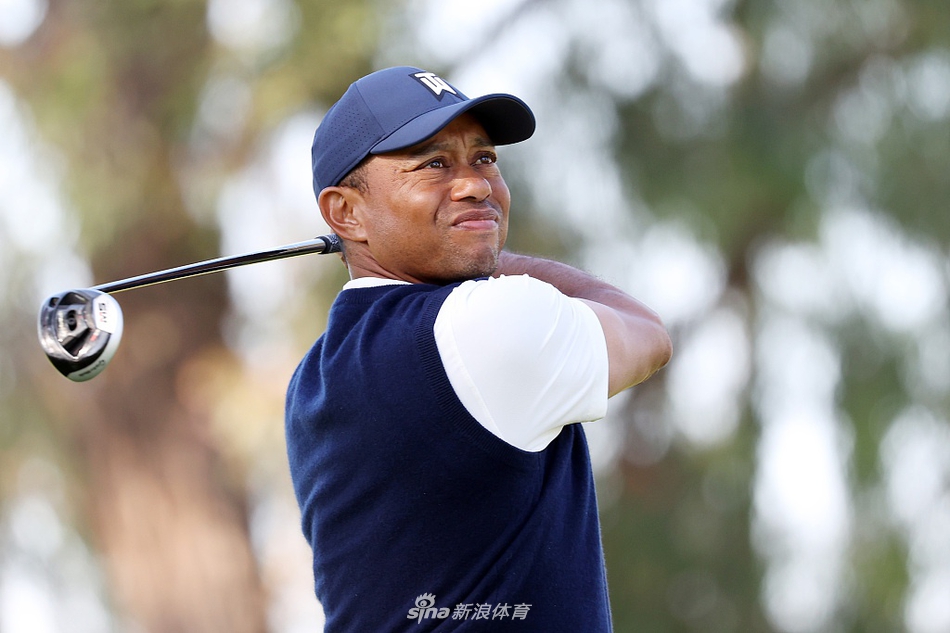 老虎伍兹在发球台上完成一次流畅的一号木挥杆,身体扭转充满力量,目光坚定追随着球飞出的轨迹。