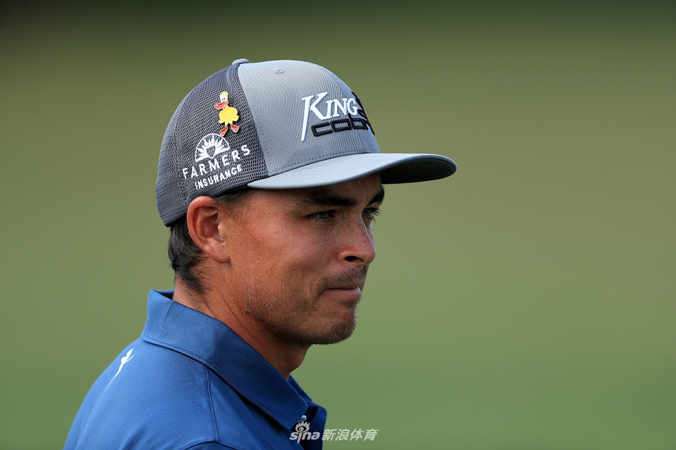 里奇·福勒身着橙色战袍，在练习日阳光下专注地进行铁杆击球练习，目光坚定地望向远方落点