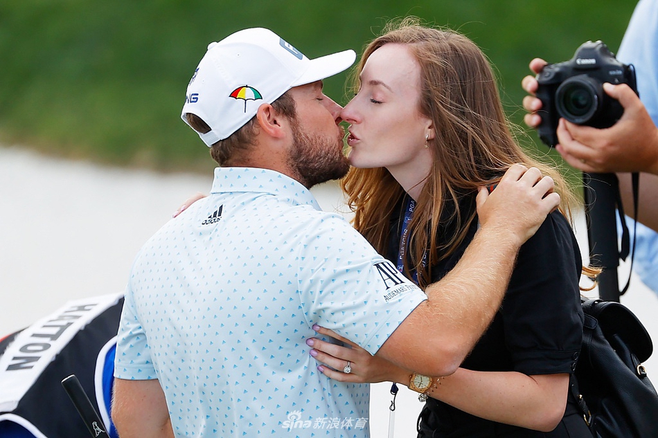 身着红色冠军开衫的哈顿，手捧奖杯，在记分板前留下经典的冠军肖像照。