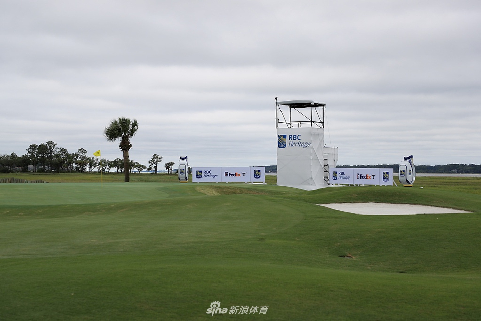 清晨薄雾中的球场练习果岭,球员们正在为一天的比赛做最后的热身,氛围专注而宁静。