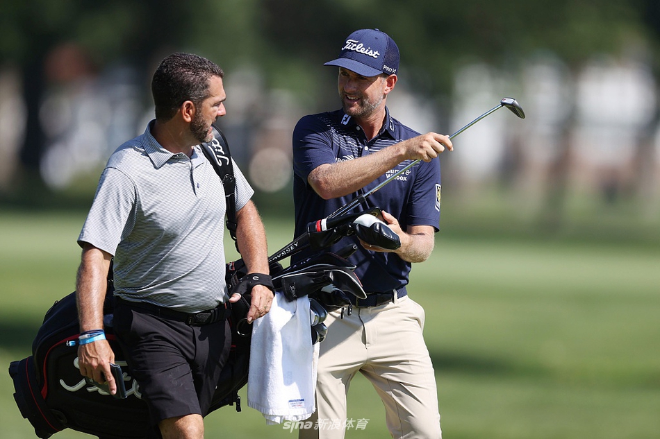 表演赛现场全景，绿草如茵的球道上散布着球员与观众，展现了赛事热烈而有序的整体氛围。