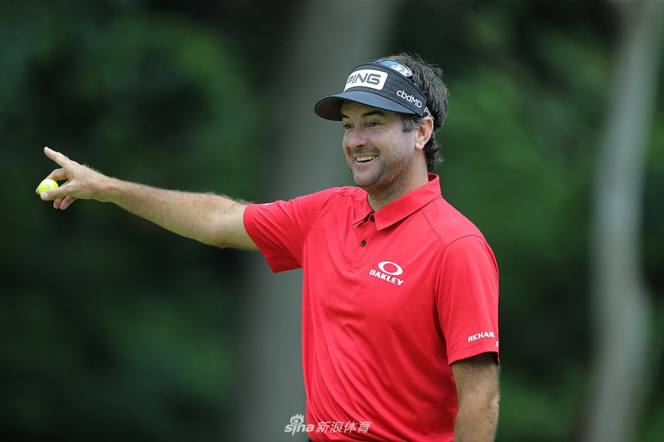 简森-戴伊在果岭边凝神观察推杆线路，表情专注，阳光为其身影勾勒出金色的轮廓。