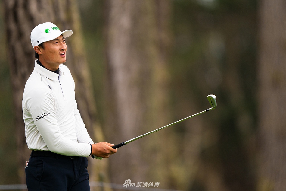 李昊桐在PGA锦标赛练习日专注地观察果岭推击线路，目光如炬