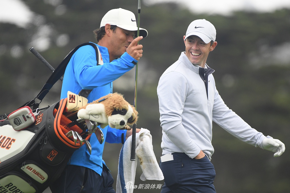 托马斯在果岭边细致地进行切杆练习，表情严肃认真，追求极致手感