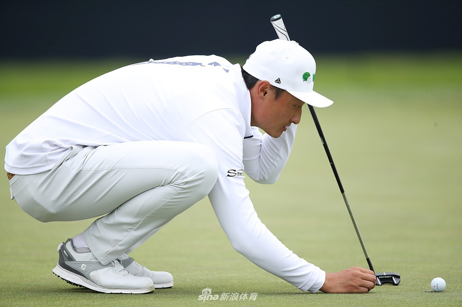 李昊桐完成精彩推杆后握拳庆祝，脸上洋溢着自信的笑容，身后是广阔的球场与观众