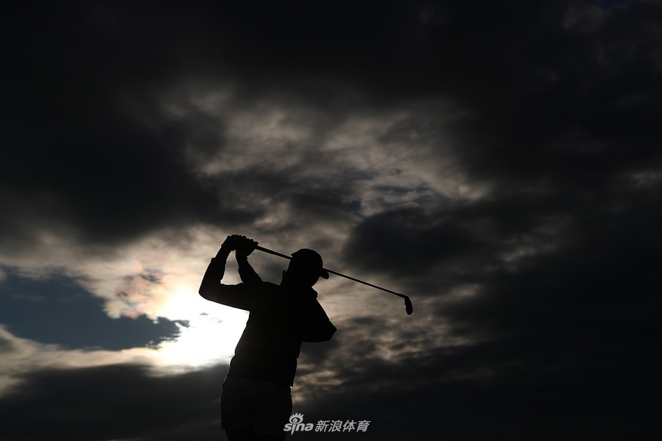 艾莉森-李专注观察果岭线,手握推杆凝神思考,远处是特隆球场连绵的沙丘