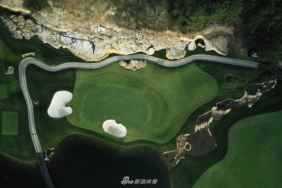 开阔的球道引导视线穿越湖泊与桥梁，直达远方的发球台，体现了球场设计的层次感和引导性。