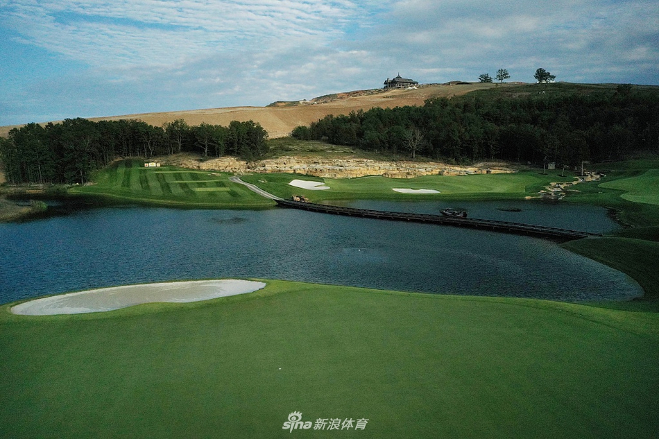 赛事中球员正专注推击，背景是起伏的果岭与远山，展现了竞技与自然环境的结合。