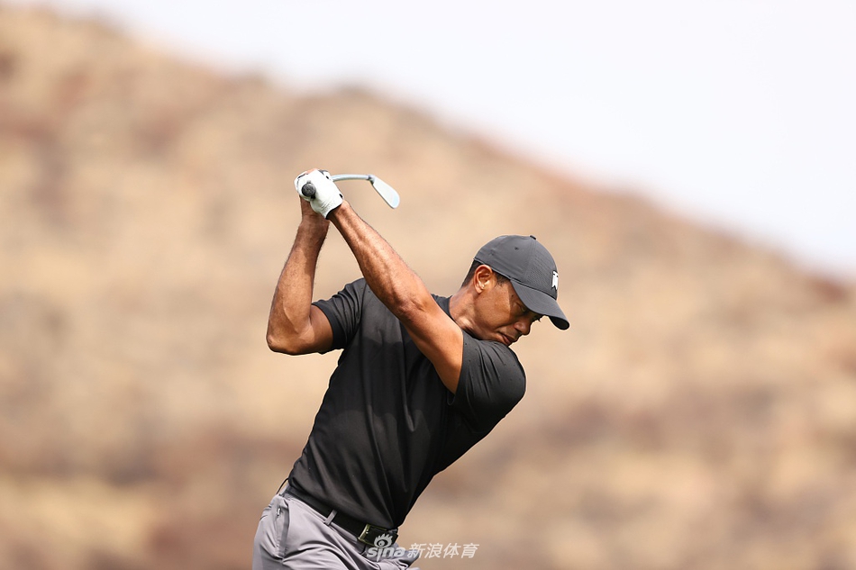 果岭边，伍兹手握挖起杆，正全神贯注地执行一记精巧的切球，试图将球送到洞杯附近。