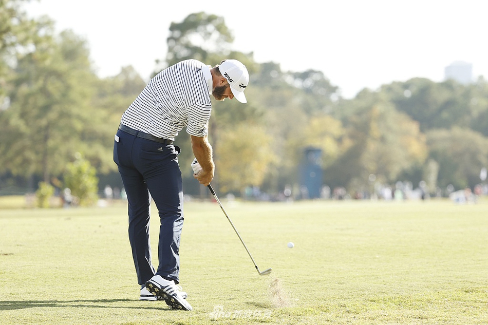 达斯汀·约翰逊在开球台上全力挥杆,阳光勾勒出他强壮的身形,世界第一的力量感展露无遗。