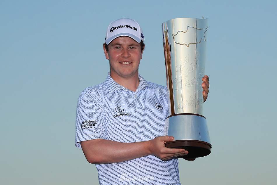 麦金泰尔与球童在果岭边仔细研究推杆线路，两人专注的神情体现出决赛轮的紧张气氛。