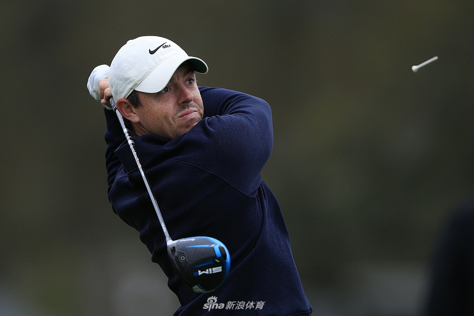 麦克罗伊在湾丘俱乐部球道上全神贯注，准备击出关键一杆，神情专注而坚定。