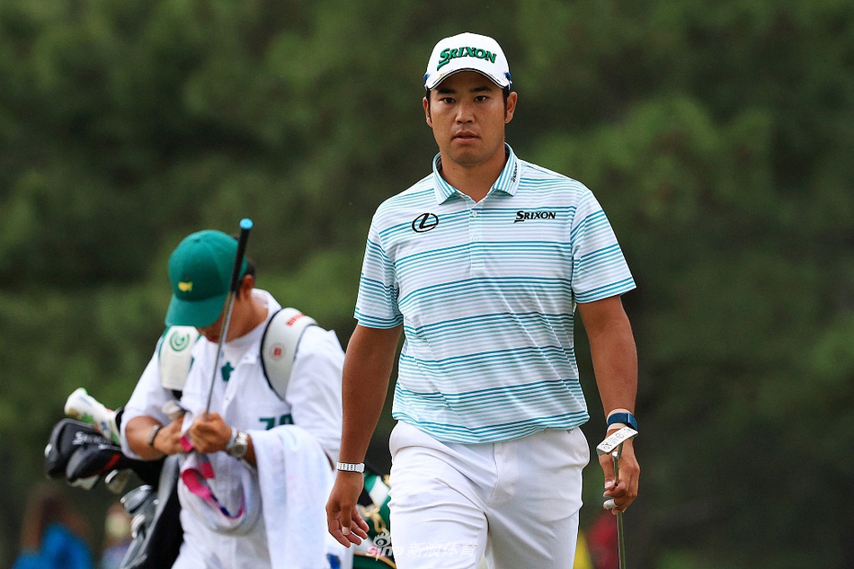 松山英树在第18洞果岭推入决定性一推后，紧闭双眼仰天长舒一口气，手中紧握的推杆与身后肃立的记分牌共同见证了这一历史时刻。