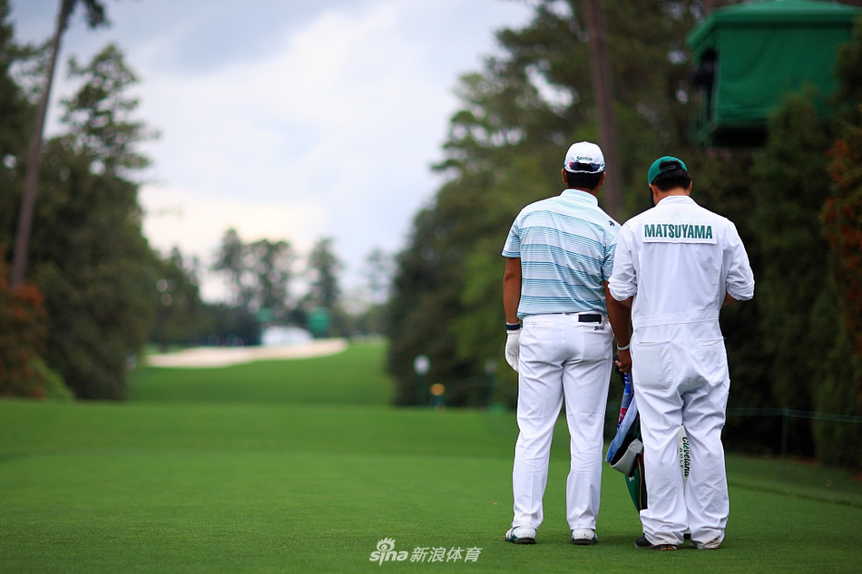 科里·康纳斯在某一洞果岭边凝视线路，阳光勾勒出他专注的侧影，展现了大赛中球员面对关键一击时的凝神静思。