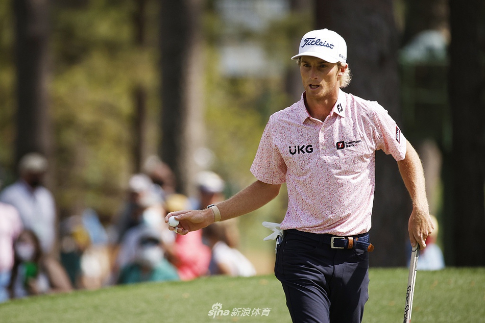 身着绿夹克的松山英树在暮色中的奥古斯塔第18洞果岭畔,手持奖杯,眼含热泪,与身后辉煌的俱乐部会馆共同构成历史性画面。