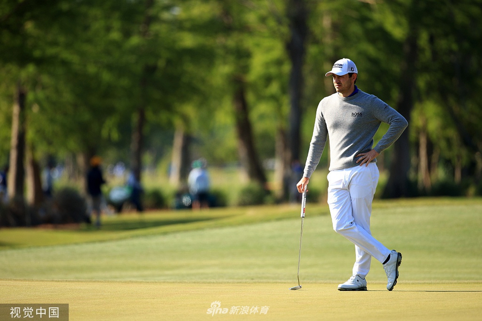 马修-沃尔夫展现其标志性高挥杆顶点，在绿意盎然的球道上挥击。