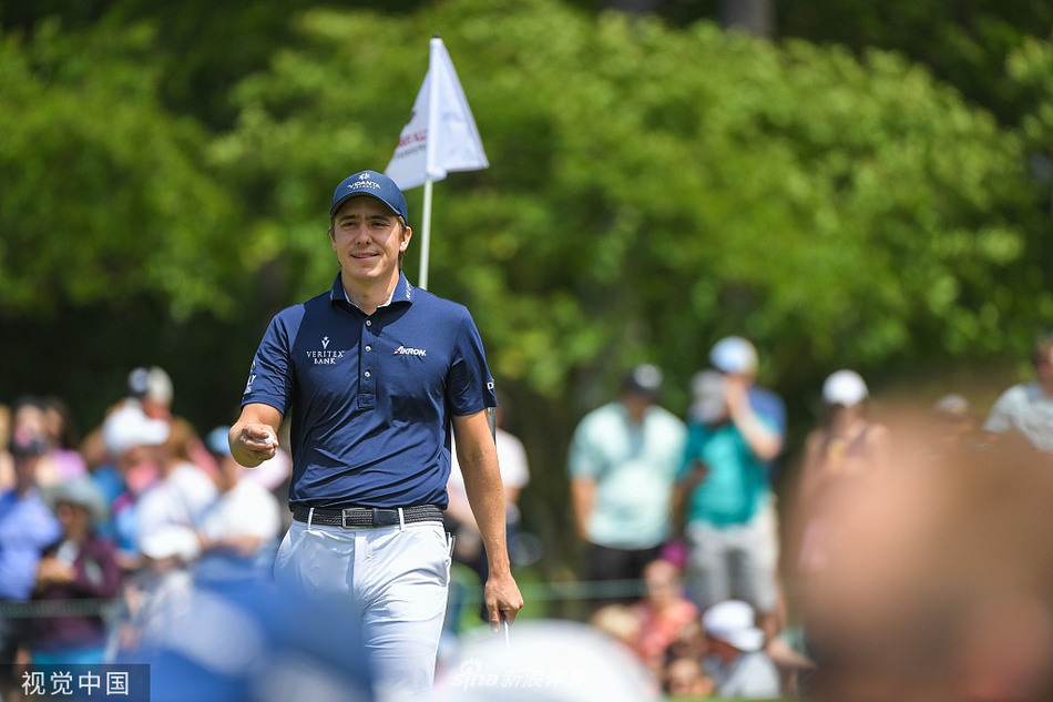 夕阳下，米切尔推杆进洞后握拳庆祝，表情坚定