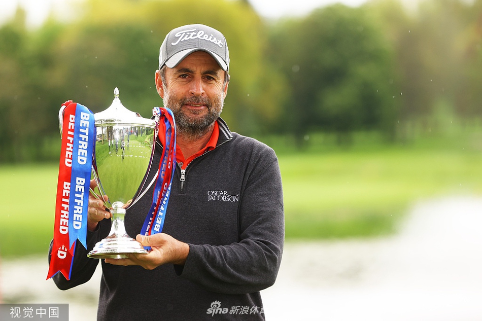 理查德·布兰德手捧冠军奖杯，脸上绽放着难以置信的灿烂笑容，眼中闪烁着激动的泪光。